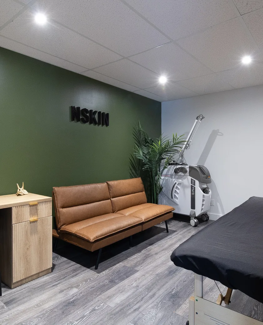 Salle de traitement de la Clinique NSKIN, avec son mur vert signé NSKIN et son laser Quanta